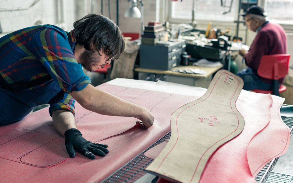 Джордж Гарсия обрезает материал, который будет использован для создания ремня. Саакян, который на самом деле официально в отставке, проводит почти все свое время в мастерской, наблюдая за производством.