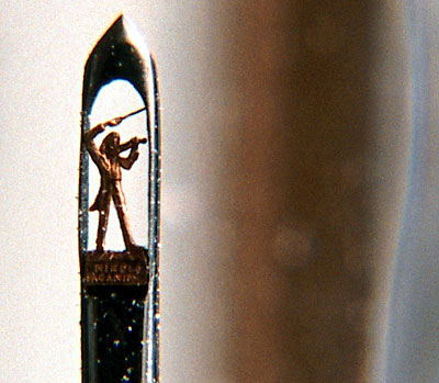 Золотая статуэтка Паганини, помещенная внутри ушка иглы. Лицо музыканта в 50 раз меньше крупицы.